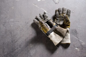 Worn work gloves lying on concrete floor