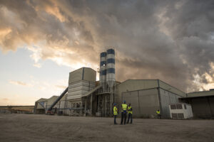 workers in a cement factory work outdoors with a tablet planning their work and checking concrete structures