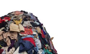 large pile stack of textile fabric clothes and shoes