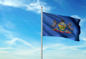 Pennsylvania state of United States flag waving cloudy sky background