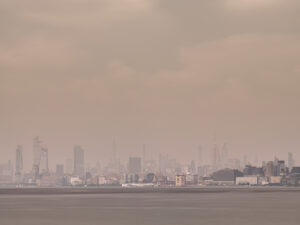 Long exposure of Hudson Yards and Midtown Manhattan across the Hudson River on a hazy day where the Canadian fire smoke engulfs the city including the Empire State Building and the Chrysler Building