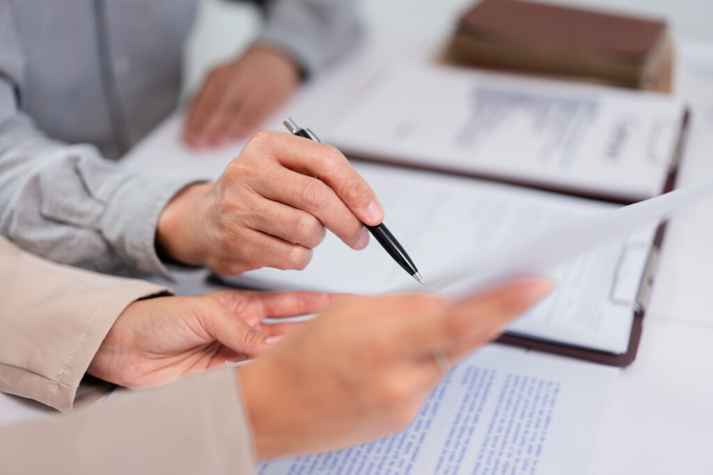 Senior businessman pointing on contract to asking about term and legal agreement with female lawyer