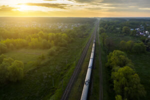 Freight train on the railroad at sunrise. Aerial view