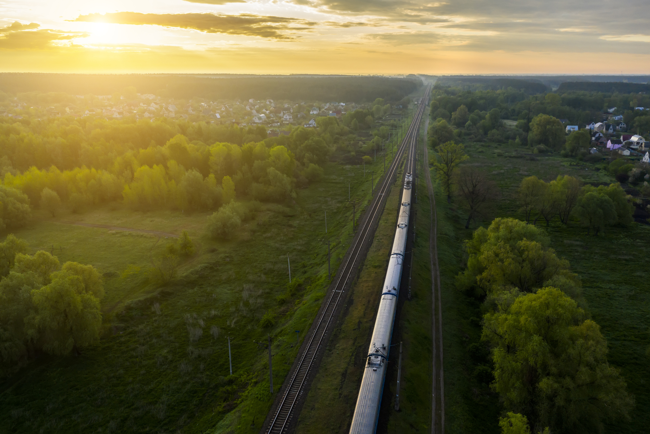 Freight train on the railroad at sunrise. Aerial view