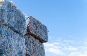 Recyclable plastic materials stacked at waste sorting plant and sky