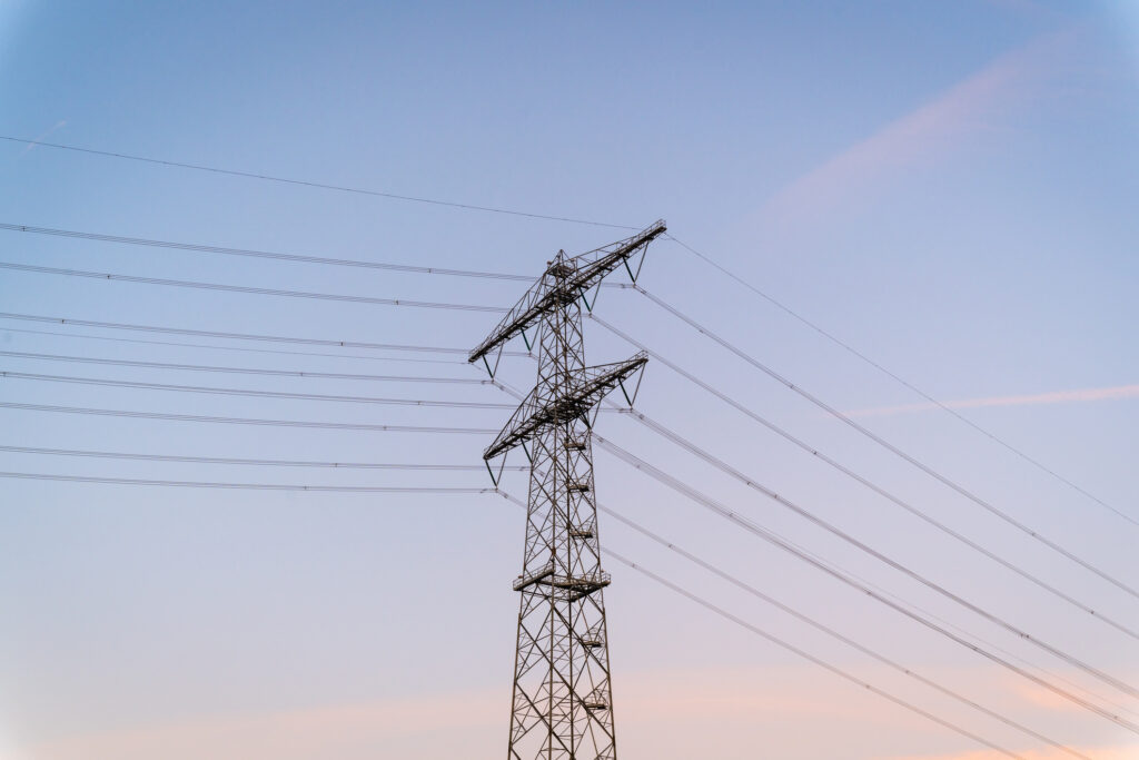 Electricity pylon against pastel sky