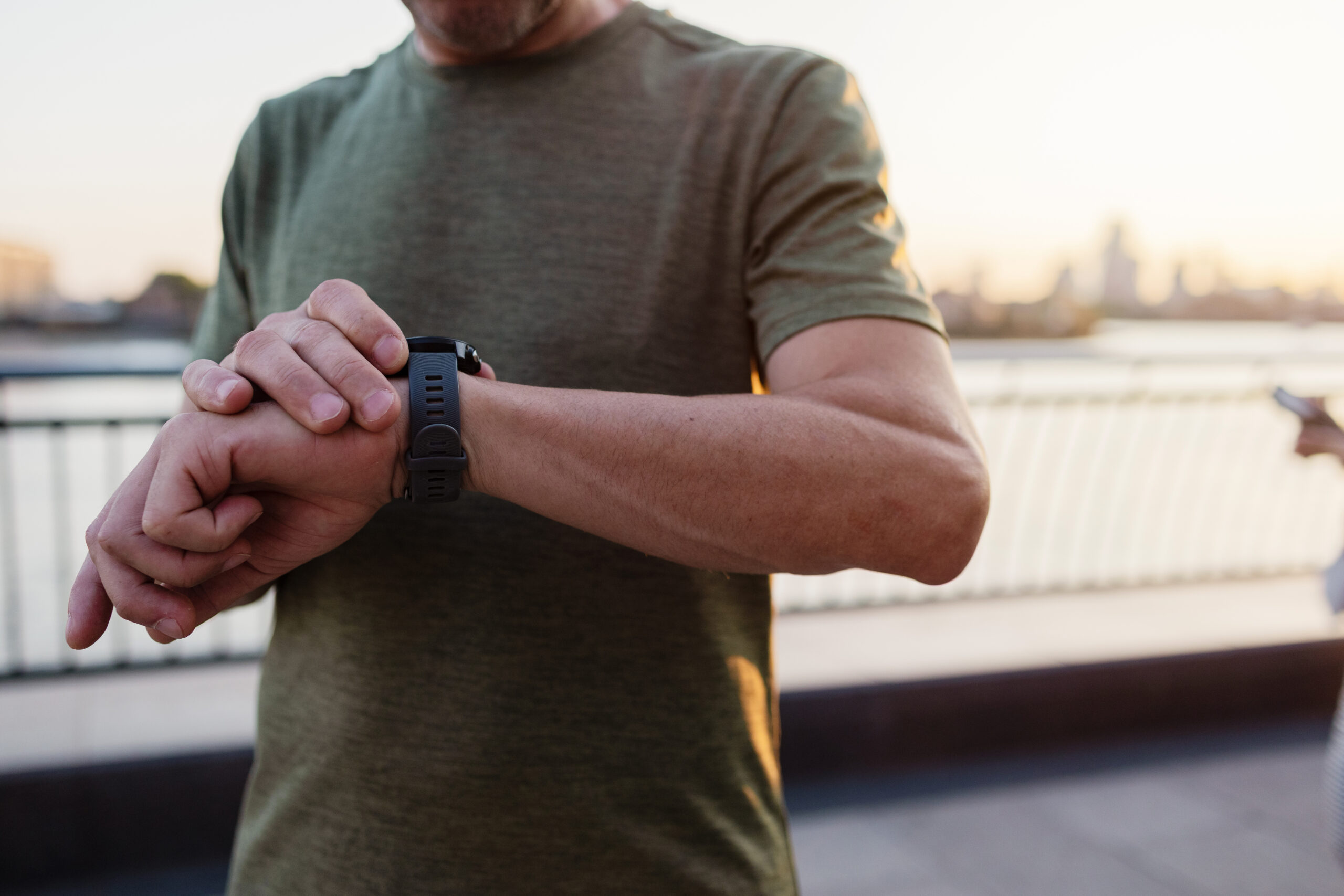 Mature adult man checking smartwatch after running in the city